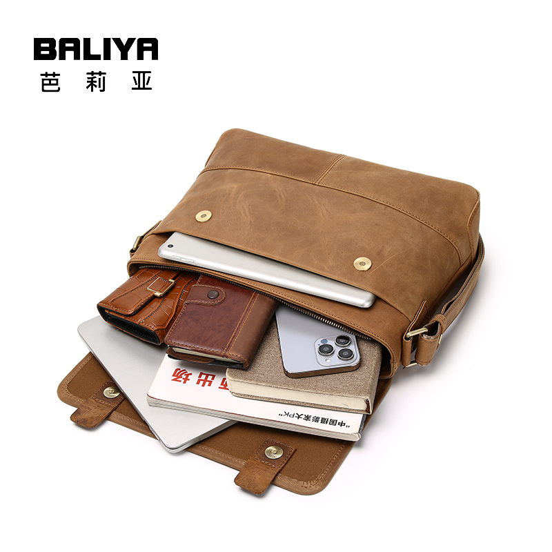 This BALIYA messenger bag, crafted from brown Crazy Horse leather, showcases excellent capacity by holding a laptop, smartphone, wallet, and books, perfect for organizing daily essentials.