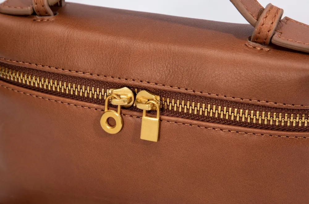 Features a premium metal zipper with smooth-gliding mechanism and polished hardware, elevating the leather clutch's sleek appeal.