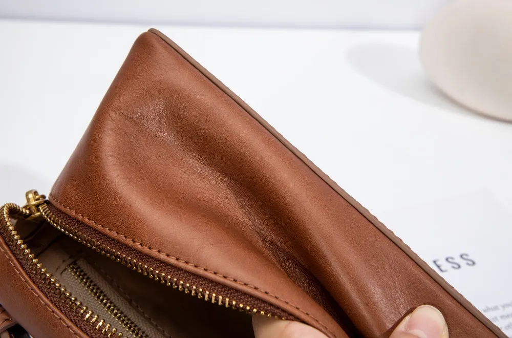 Crafted from premium genuine cowhide, the leather clutch offers a luxuriously soft texture and enduring durability.