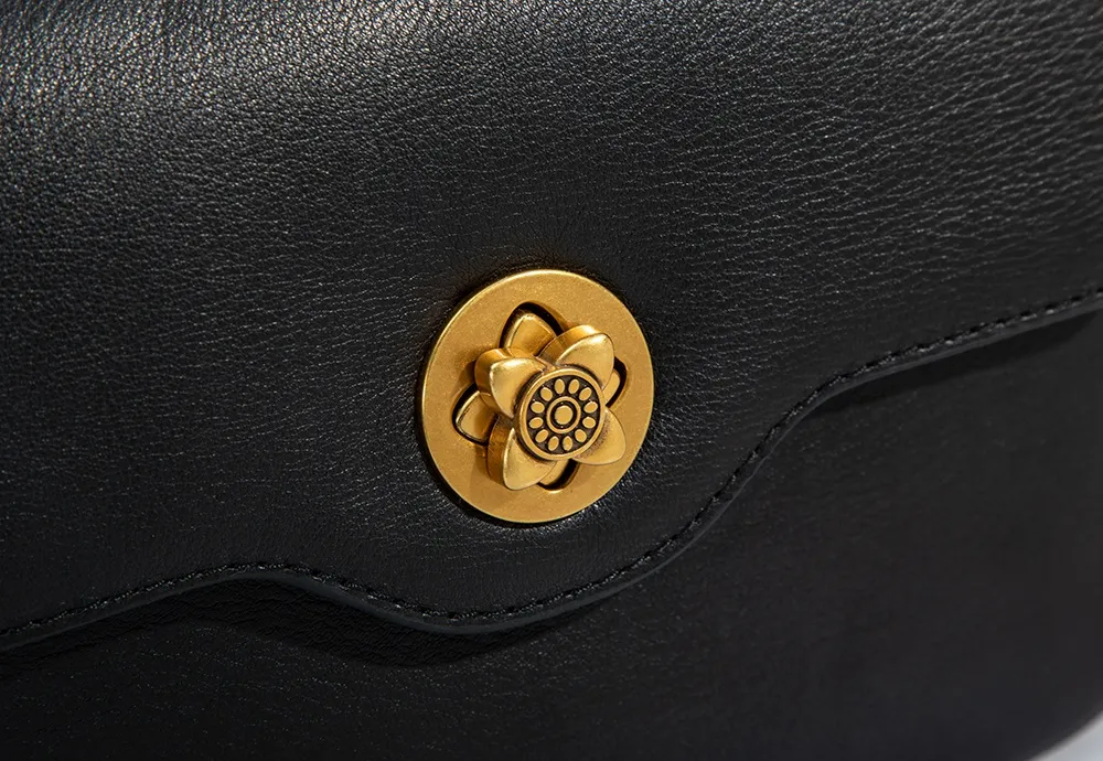 The BALIYA shoulder bag stands out with its delicate floral-inspired gold-tone clasp – each delicate petal and intricate detail has been meticulously crafted to create a striking focal point.