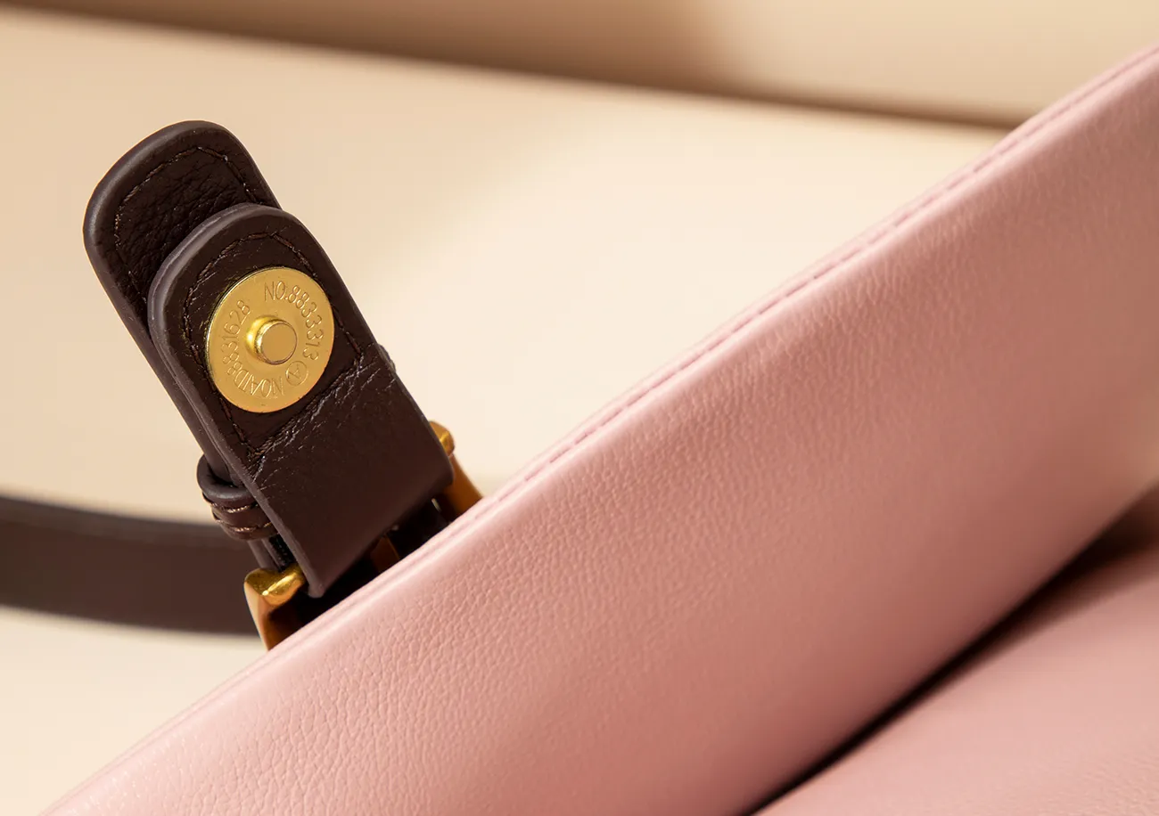 A bright contrasting color and polished magnetic clasp create a stylish detail.